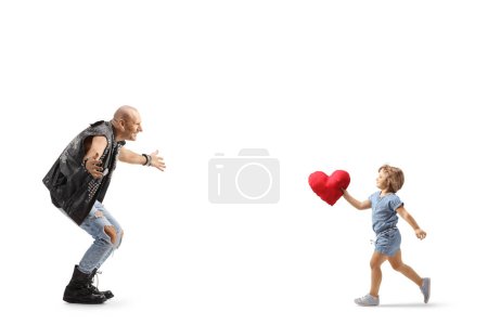 Foto de Foto de perfil completo de una niña corriendo hacia un hombre con un corazón rojo en sus brazos aislado sobre fondo blanco - Imagen libre de derechos