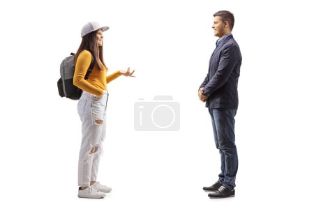 Photo for Full length profile shot of a female student with a backpack  talking to a man isolated on white background - Royalty Free Image