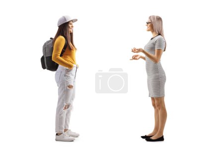 Téléchargez les photos : Conversation entre une jeune femme et une étudiante isolée sur fond blanc - en image libre de droit