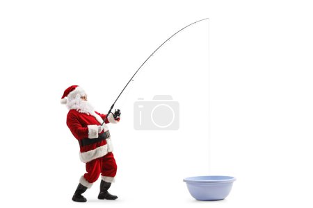 Photo for Full length profile shot of santa claus fishing in a washing basin isolated on white background - Royalty Free Image