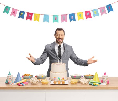 Téléchargez les photos : Homme se préparant à une fête d'anniversaire avec gâteau et faveurs de fête sur un comptoir isolé sur fond blanc - en image libre de droit