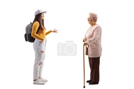 Téléchargez les photos : Conversation entre une jeune étudiante et une femme âgée isolée sur fond blanc - en image libre de droit