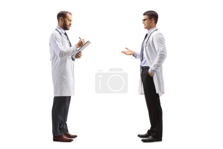 Téléchargez les photos : Médecin parlant à un collègue debout et écrivant un document isolé sur fond blanc - en image libre de droit