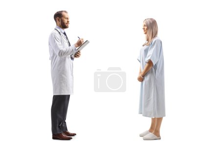 Foto de Médico varón escribiendo un documento y hablando con una paciente hospitalizada aislada sobre fondo blanco - Imagen libre de derechos
