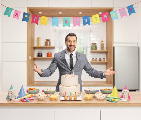 Photo for Elegant man preparing for a birthday celebration with cake and party favors on a kitchen counter - Royalty Free Image