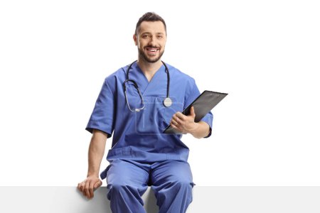 Téléchargez les photos : Travailleur de la santé en uniforme bleu assis sur un panneau blanc isolé sur fond blanc - en image libre de droit