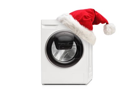 Téléchargez les photos : Plan studio d'une nouvelle machine à laver avec un chapeau santa claus isolé sur fond blanc - en image libre de droit