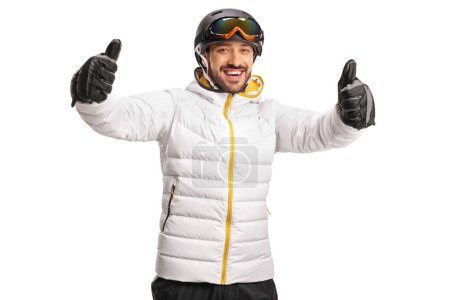 Foto de Feliz esquiador masculino haciendo gestos con ambos pulgares delante de la cámara aislados en el fondo blanco - Imagen libre de derechos
