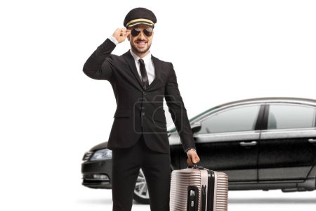 Téléchargez les photos : Chauffeur portant une valise et saluant avec son bonnet devant une voiture isolée sur fond blanc - en image libre de droit
