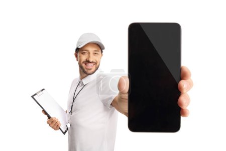 Photo for Sports coach with a whistle holding a clipboard and showing a smartphone isolated on white background - Royalty Free Image