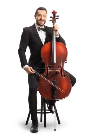 Photo for Male musician in a black suit and bow-tie sitting on a chair with a cello isolated on white background - Royalty Free Image