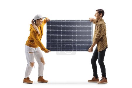 Foto de Foto de perfil de cuerpo entero de un joven hombre y una mujer llevando un panel solar aislado sobre fondo blanco - Imagen libre de derechos