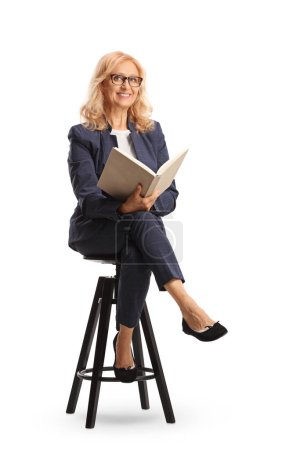 Foto de Mujer profesional sentada en una silla y sosteniendo un libro aislado sobre fondo blanco - Imagen libre de derechos