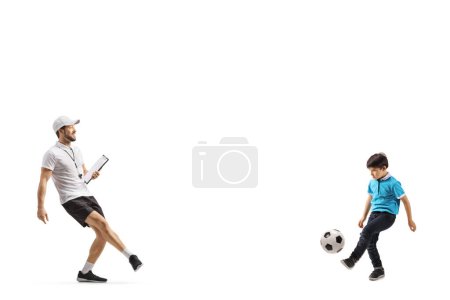 Foto de Entrenador de fútbol jugando al fútbol con un niño aislado en el fondo blanco - Imagen libre de derechos