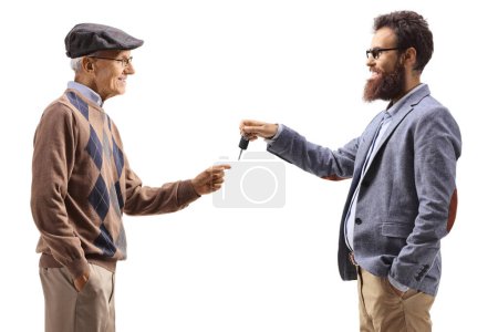 Foto de Hombre más joven dando llaves de coche a un anciano aislado sobre fondo blanco - Imagen libre de derechos