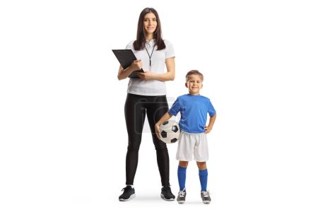 Foto de Niño con un balón de fútbol de pie junto a una entrenadora deportiva aislada sobre fondo blanco - Imagen libre de derechos