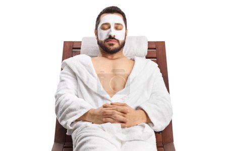 Téléchargez les photos : Portrait d'un jeune homme avec un masque facial relaxant isolé sur fond blanc - en image libre de droit