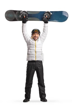 Foto de Retrato de cuerpo entero de un hombre excitado levantando una tabla de snowboard aislada sobre fondo blanco - Imagen libre de derechos