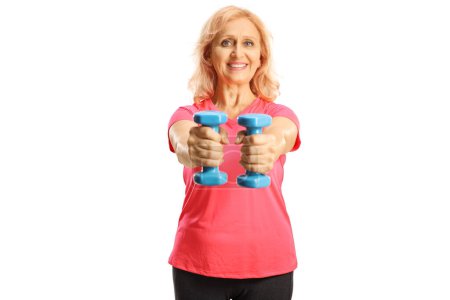 Photo for Smiling mature woman exercising with blue dumbbells isolated on white background - Royalty Free Image