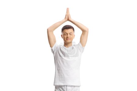 Photo for Young man standing and practicing yoga with closed eyes isolated on white background - Royalty Free Image