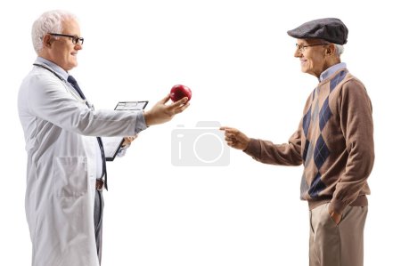 Téléchargez les photos : Profil d'un médecin donnant une pomme à un homme âgé isolé sur fond blanc - en image libre de droit