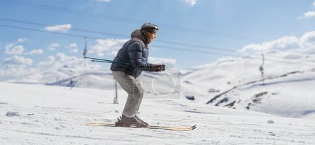 Foto de Perfil de longitud completa de un hombre maduro esquiando cuesta abajo en una montaña - Imagen libre de derechos