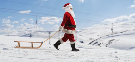Photo for Full length profile shot of santa claus pulling a wooden sleigh on a snowy mountain - Royalty Free Image