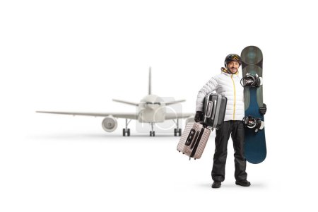 Foto de Retrato completo de un hombre con una tabla de snowboard y maletas esperando un vuelo aislado sobre fondo blanco - Imagen libre de derechos