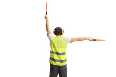 Téléchargez les photos : Rear view shot of an aircraft marshaller signalling with wands isolated on white background - en image libre de droit