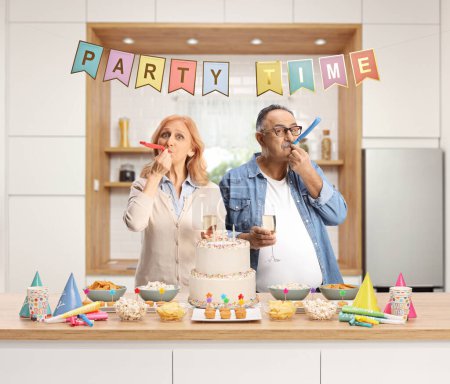 Téléchargez les photos : Mature homme et femme préparant une fête et posant à l'intérieur d'une cuisine - en image libre de droit