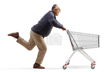 Téléchargez les photos : Excited mature man running with an empty shopping cart isolated on white background - en image libre de droit