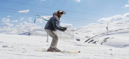 Foto de Full length profile shot of a mature man skiing with a vr headset on a snowy hill - Imagen libre de derechos