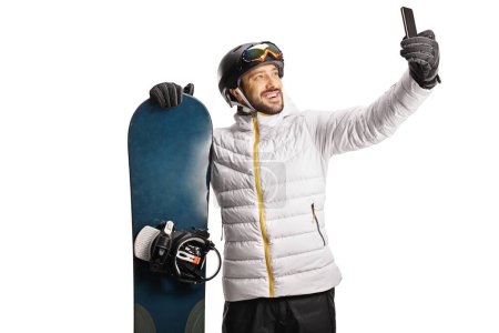 Photo for Man with a snowboard taking a selfie with a smartphone isolated on white background - Royalty Free Image