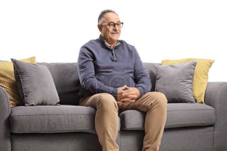 Photo for Smiling mature man sitting on a sofa isolated on white background - Royalty Free Image