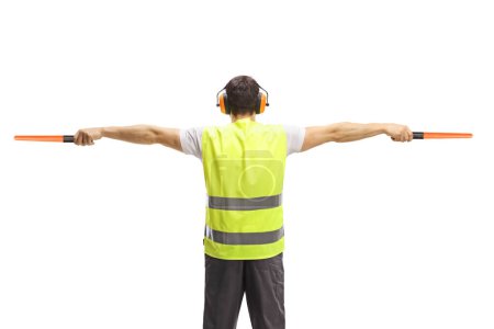 Back view of an aircraft marshaller signalling with wands isolated on white background