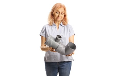 Foto de Confused woman looking at a plastic water pipe isolated on white background - Imagen libre de derechos