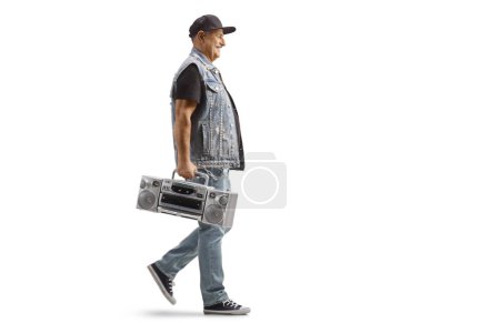 Photo for Full length profile shot of a mature man walking and carrying a boombox radio isolated on white background - Royalty Free Image