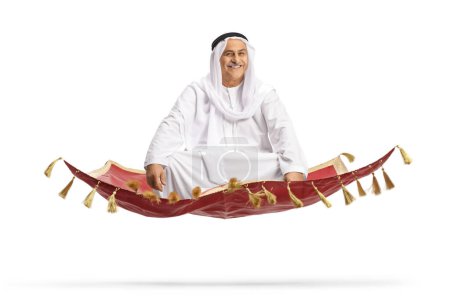 Photo for Mature arab man sitting on a carpet and flying isolated on white background - Royalty Free Image