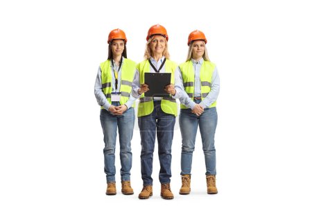 Foto de Team of female site engineers with safety vests and hardhats isolated on white background - Imagen libre de derechos