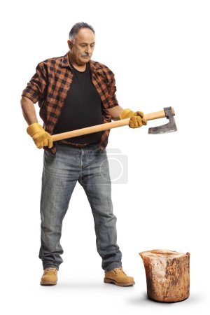 Photo for Full length portrait of a mature man cutting wood with an axe isolated on blue background - Royalty Free Image