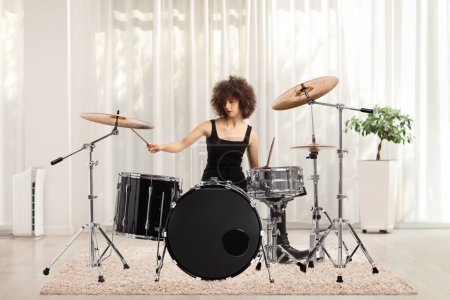 Téléchargez les photos : Young female playing drums inside a room - en image libre de droit
