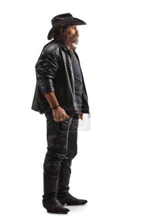 Photo for Full length profile shot of a man in leather clothes and a black cowboy hat isolated on white background - Royalty Free Image