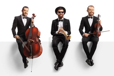 Photo for Male musicians seated on a blank panel with a cello, violin and a trumpet isolated on white background - Royalty Free Image