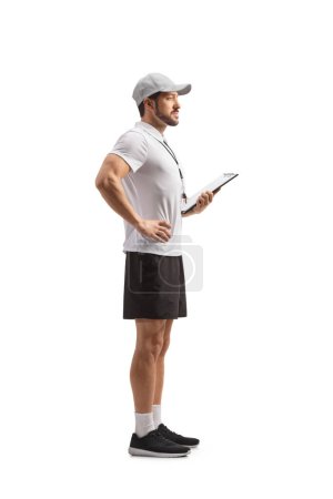 Téléchargez les photos : Full length profile shot of a sports coach holding a clipboard isolated on white background - en image libre de droit