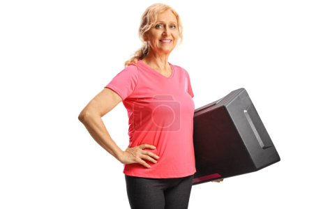 Photo for Beautiful mature woman holding a step aerobic platform and smiling isolated on white background - Royalty Free Image