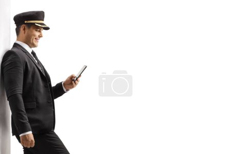 Photo for Chauffeur standing and typing on a mobile phone isolated on white background - Royalty Free Image