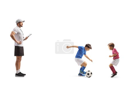 Photo for Coach watching two boys playing football isolated on white background - Royalty Free Image