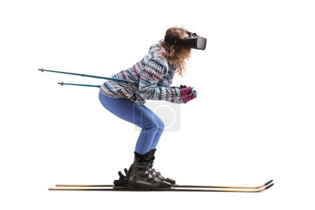 Foto de Foto de perfil completo de una joven esquiando y con un casco de realidad virtual aislado sobre fondo blanco - Imagen libre de derechos