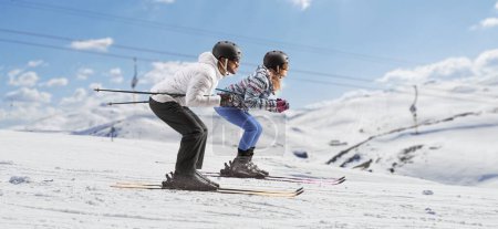 Foto de Foto de perfil completo de una joven pareja esquiando en una montaña - Imagen libre de derechos