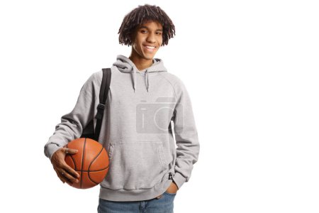 Téléchargez les photos : Young african american male with a backpack holding a basketball and smiling isolated on white background - en image libre de droit